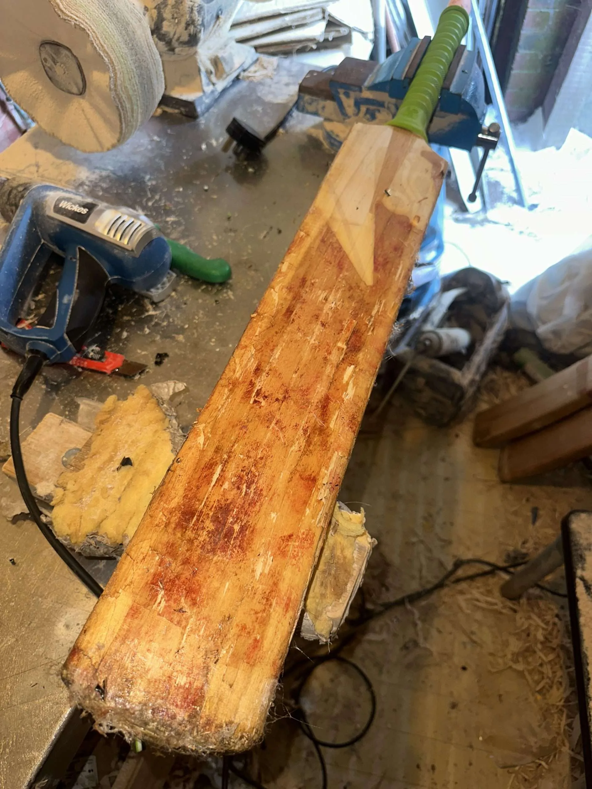 Cricket bat before repair, showing cracks and wear